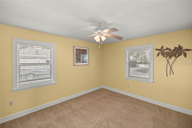 carpeted spare room featuring ceiling fan