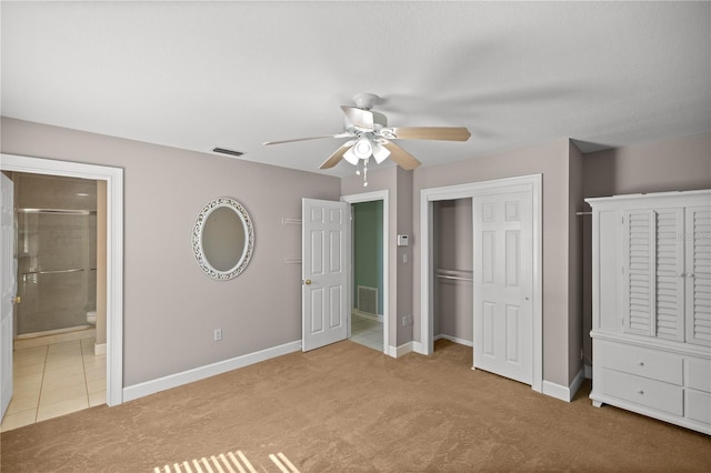 unfurnished bedroom with ceiling fan, light colored carpet, ensuite bath, and a closet