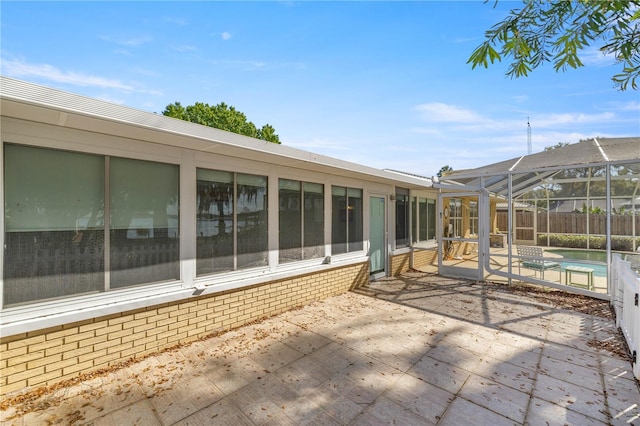 view of patio featuring a fenced in pool and glass enclosure