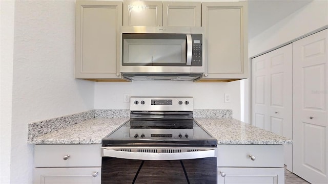 kitchen with appliances with stainless steel finishes and light stone counters