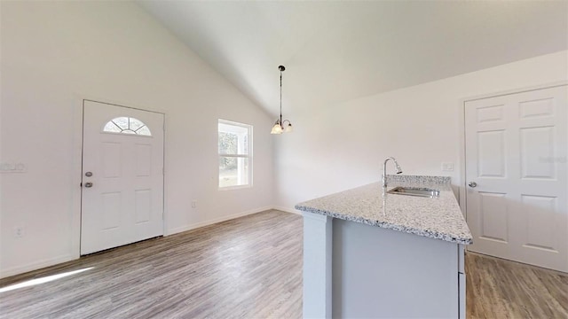 entryway featuring sink, vaulted ceiling, and light wood-type flooring