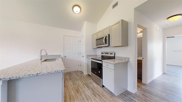 kitchen featuring sink, gray cabinetry, stainless steel appliances, light stone counters, and light hardwood / wood-style floors