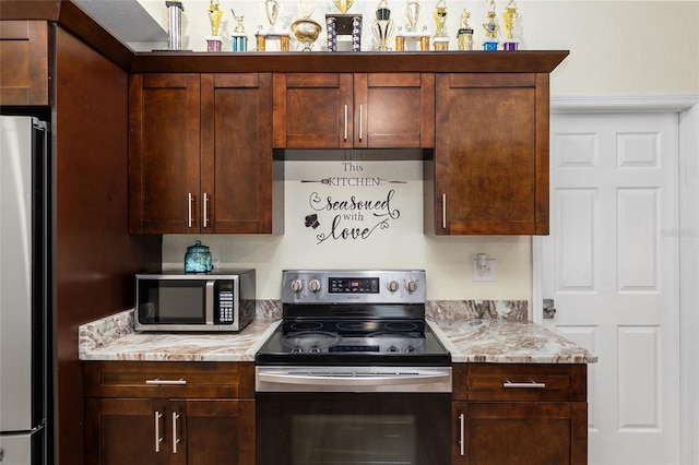 kitchen with appliances with stainless steel finishes and light stone counters