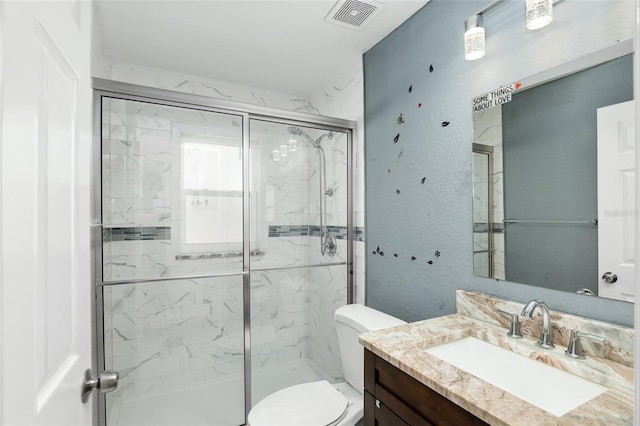 bathroom with walk in shower, vanity, and toilet