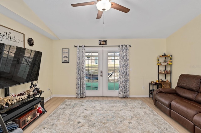 living room with french doors, vaulted ceiling, ceiling fan, and light hardwood / wood-style flooring