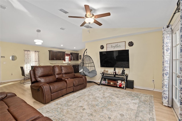 living room featuring ceiling fan, lofted ceiling, light hardwood / wood-style flooring, and plenty of natural light