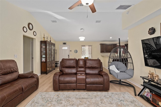 living room featuring lofted ceiling, light hardwood / wood-style floors, and ceiling fan