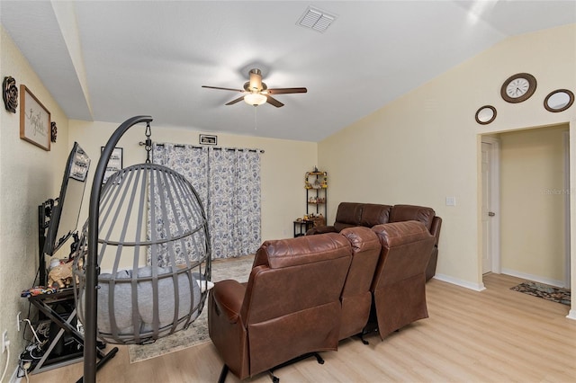 living room with lofted ceiling, ceiling fan, and light wood-type flooring