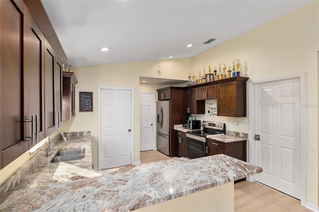 kitchen featuring dark brown cabinetry, sink, vaulted ceiling, and stainless steel appliances