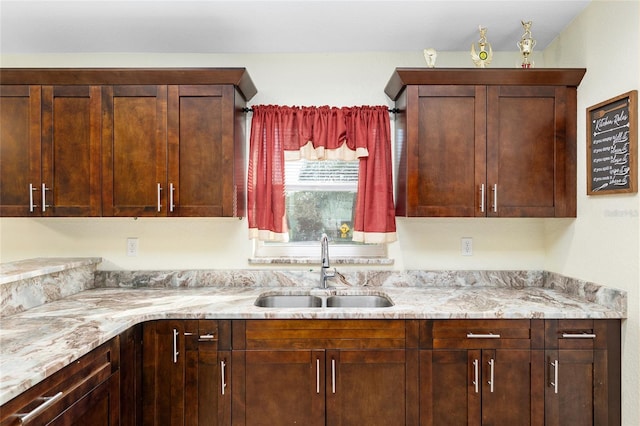 kitchen with light stone countertops and sink