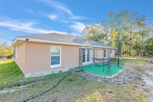 rear view of property featuring a yard, a gazebo, and french doors