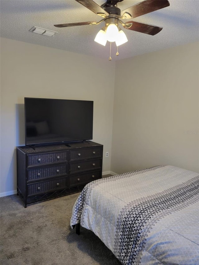 bedroom featuring ceiling fan, light colored carpet, and a textured ceiling