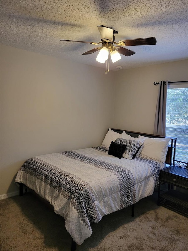 carpeted bedroom featuring ceiling fan and a textured ceiling