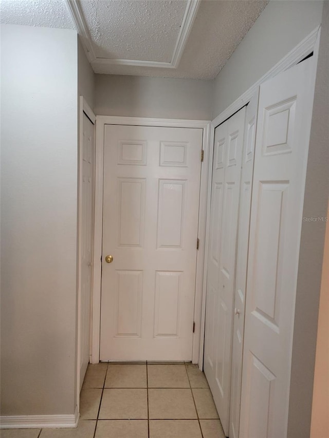 hallway featuring light tile patterned floors and a textured ceiling