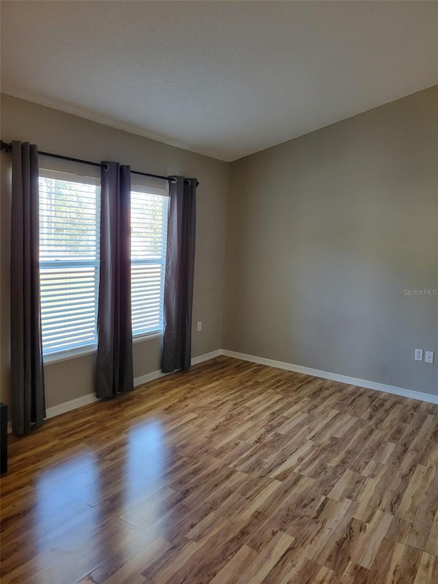 unfurnished room featuring hardwood / wood-style flooring