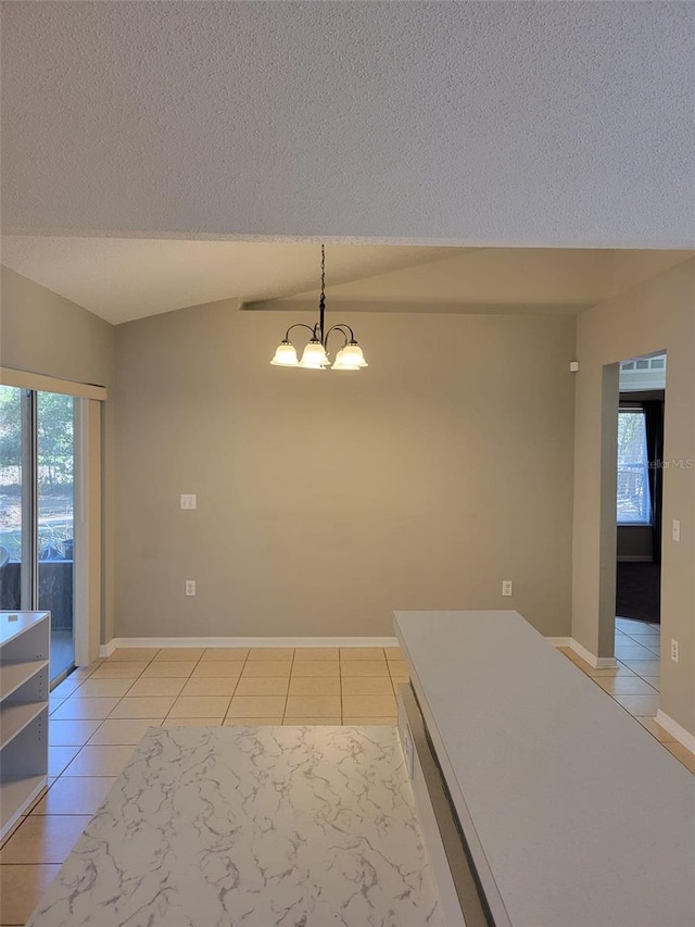 interior space with an inviting chandelier, lofted ceiling, a textured ceiling, and light tile patterned floors