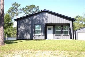 view of front of house with a garage, an outbuilding, and a front lawn