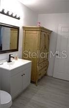 bathroom with vanity, toilet, and wood-type flooring