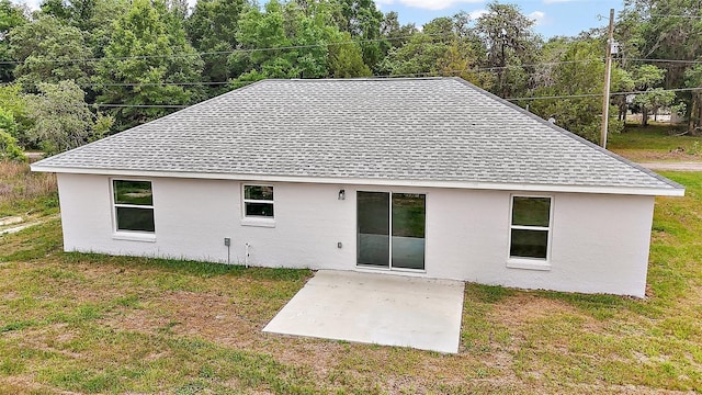 13743 SW 113th Ln, Dunnellon, FL 34432 - rear view of house featuring a lawn, a shingled roof, a patio area, and stucco siding