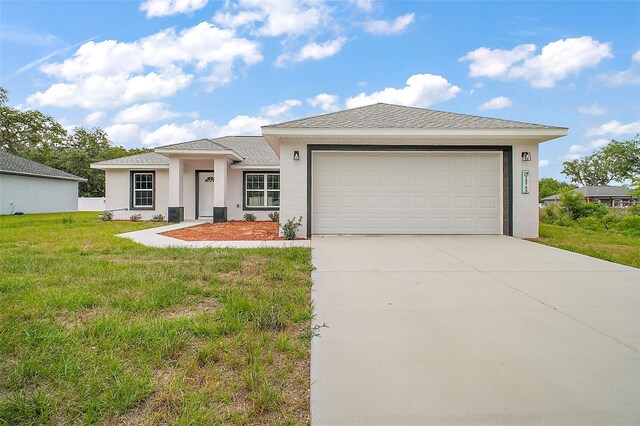 13743 SW 113th Ln, Dunnellon, FL 34432 - prairie-style home featuring an attached garage, stucco siding, driveway, and a front yard