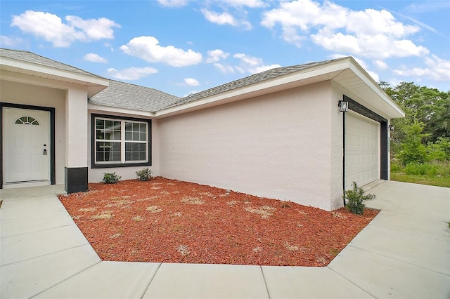 13743 SW 113th Ln, Dunnellon, FL 34432 - view of property exterior featuring an attached garage, driveway, a shingled roof, and stucco siding