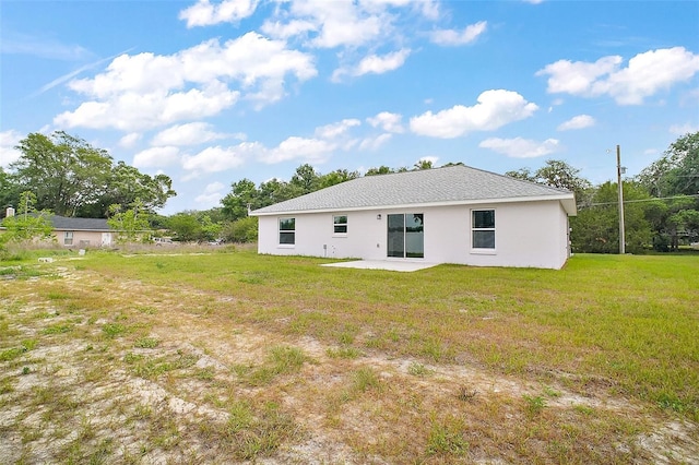 13743 SW 113th Ln, Dunnellon, FL 34432 - back of property featuring a lawn, a patio, and stucco siding