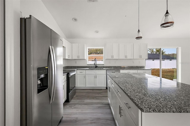 13743 SW 113th Ln, Dunnellon, FL 34432 - kitchen with a center island, a sink, white cabinets, dark stone counters, and stainless steel appliances