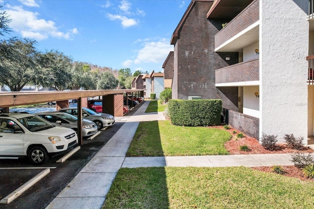 exterior space with a carport and a yard