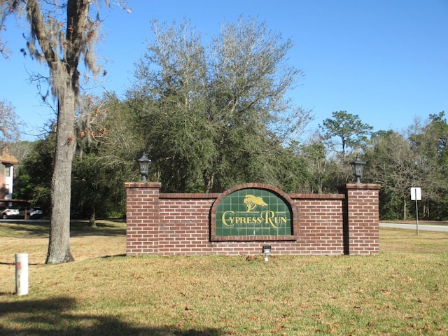 community / neighborhood sign featuring a yard