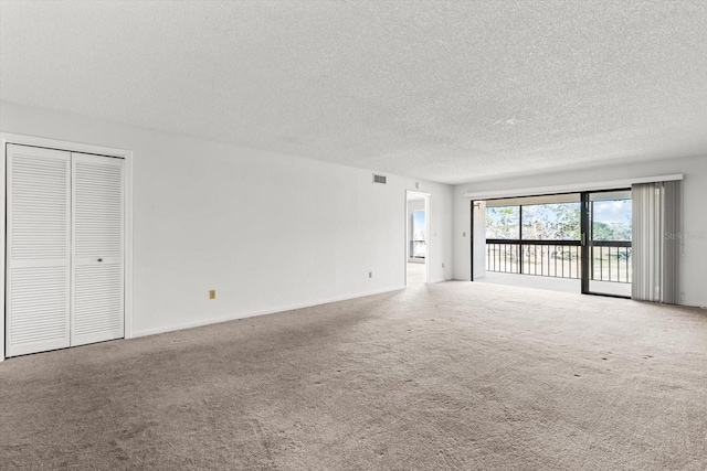 empty room with carpet flooring and a textured ceiling