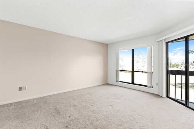 carpeted empty room featuring a textured ceiling