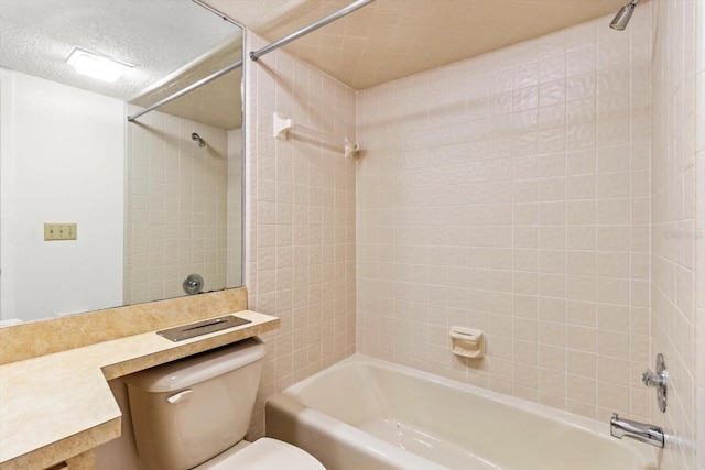 full bathroom with vanity, tiled shower / bath, a textured ceiling, and toilet