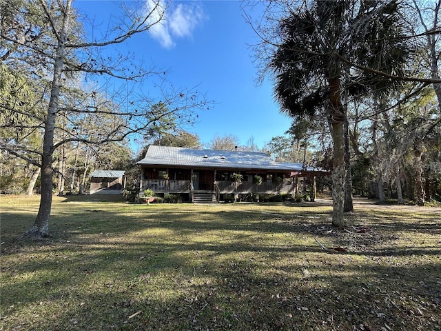 rear view of house featuring a lawn and covered porch