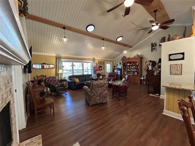 living room with lofted ceiling with beams, crown molding, dark wood-type flooring, and a fireplace