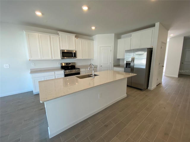 kitchen with sink, a center island with sink, white cabinets, and appliances with stainless steel finishes