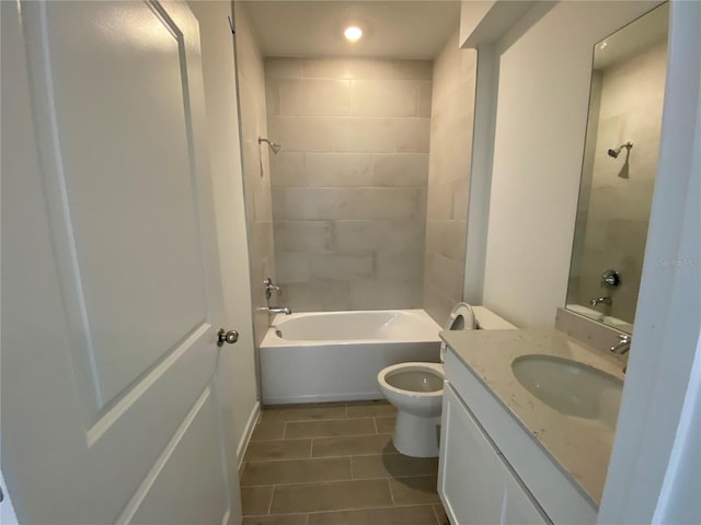 full bathroom featuring tiled shower / bath, vanity, toilet, and tile patterned floors