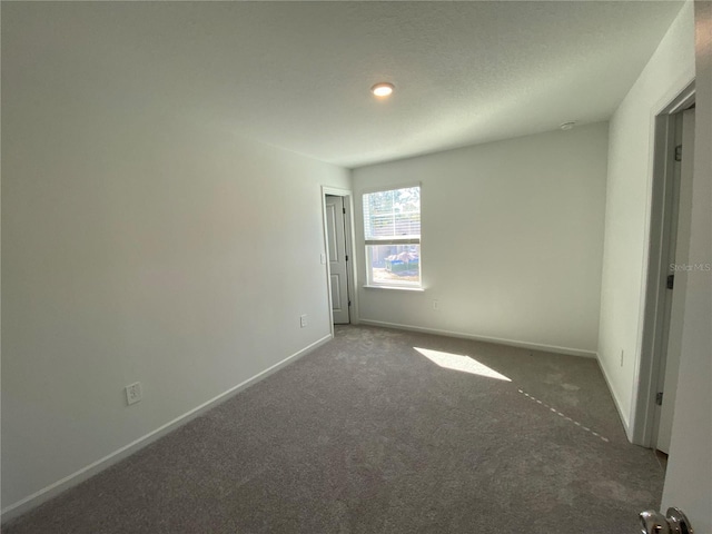 empty room featuring dark colored carpet