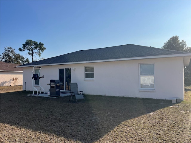 rear view of house featuring a yard