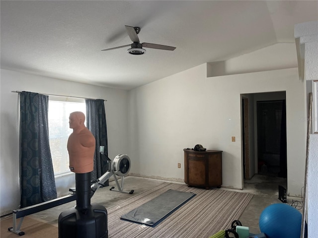 exercise room with lofted ceiling, a textured ceiling, and ceiling fan