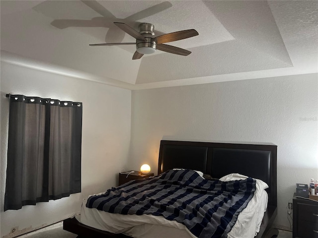 bedroom with a tray ceiling and ceiling fan