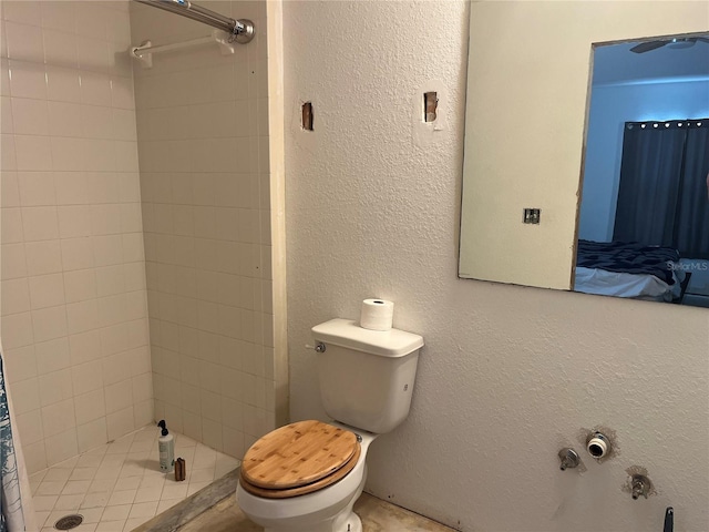 bathroom featuring toilet and a tile shower