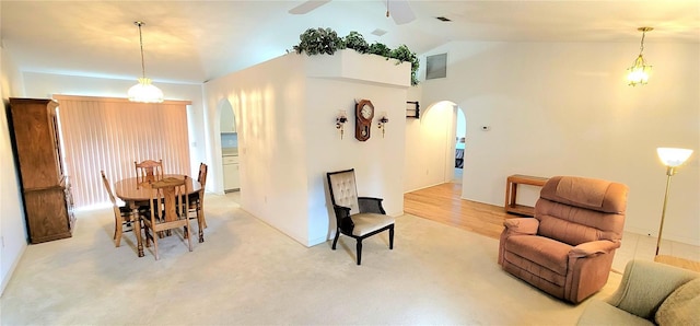 dining room featuring lofted ceiling, light carpet, and ceiling fan