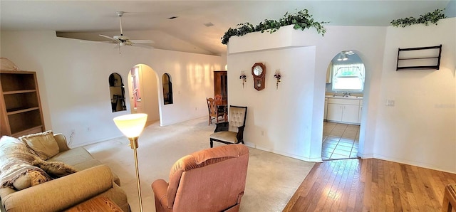 living room featuring vaulted ceiling, sink, ceiling fan, and light wood-type flooring