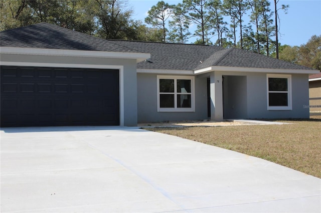 single story home with a garage and a front lawn