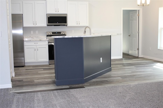 kitchen featuring appliances with stainless steel finishes, sink, hardwood / wood-style floors, and white cabinets