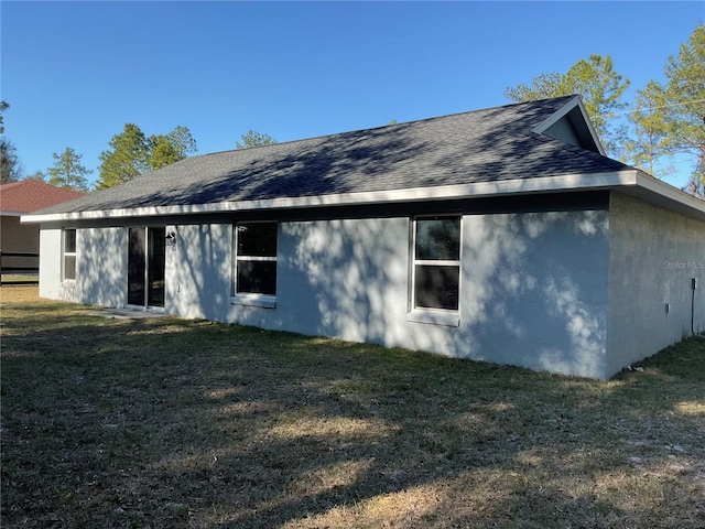 rear view of property featuring a lawn