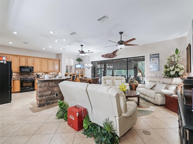 living room featuring light tile patterned floors and ceiling fan with notable chandelier