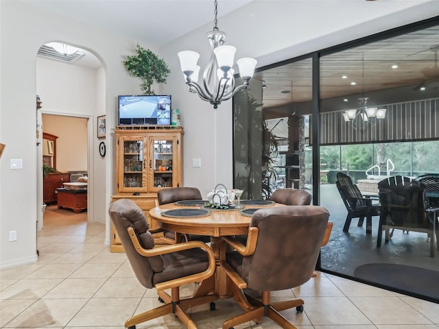 dining space featuring an inviting chandelier, light tile patterned floors, and a towering ceiling