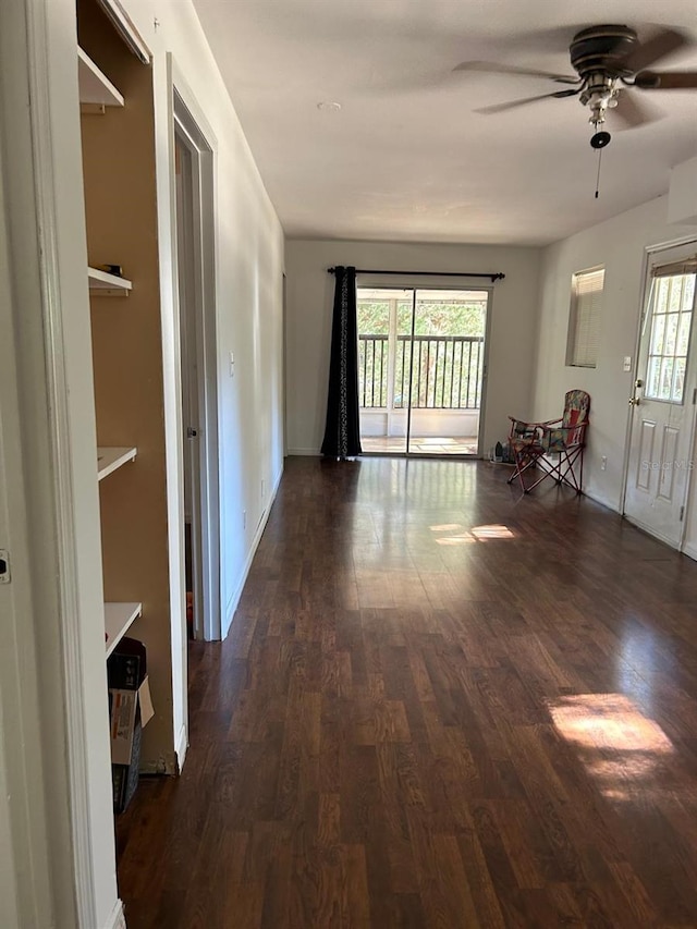 unfurnished living room with dark wood-type flooring and ceiling fan