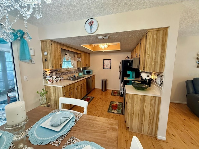 kitchen featuring stainless steel appliances, a sink, visible vents, and brown cabinets